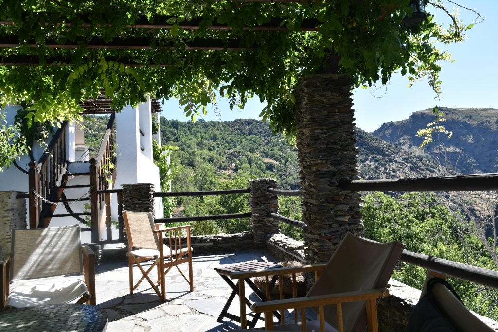 writers retreat in Spain Spanish patio with wisteria climbing over trellis and view of mountains