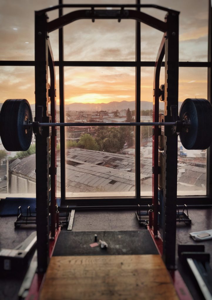 photo of weights on frame overlooking city sunset scene for blog working your writing muscles